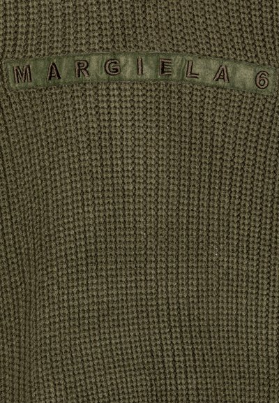 Zelená textúrovaná látka so horizontálnym panelom, na ktorom je vyšitá nálepka "MARGIELA 6" v kontrastnej farbe.