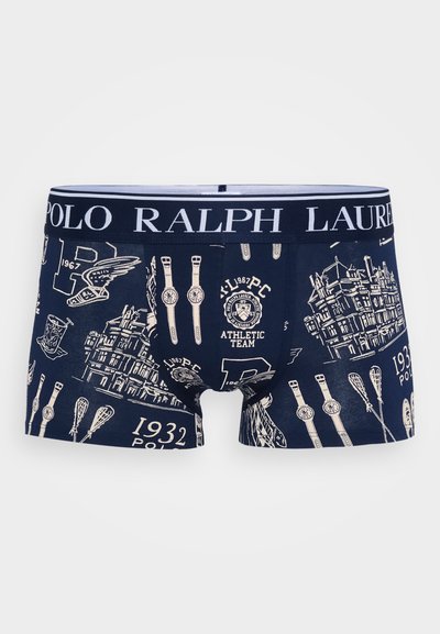 Marineblå boksershorts har en hvit linning med "POLO RALPH LAUREN." Stoffet viser forskjellige illustrasjoner, inkludert klokker og bygninger.