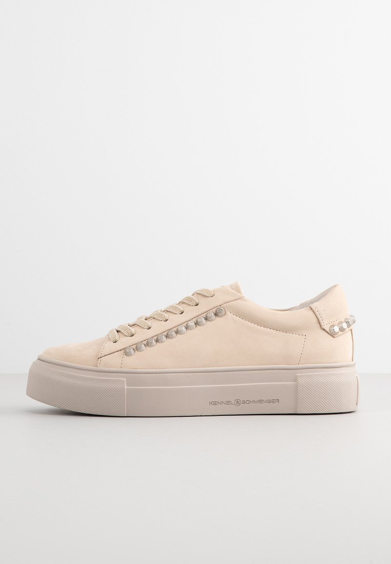 Beige Low-Top Sneakers mit dicker Sohle, schnürbarem Vorderteil, runden Nieten entlang der Seite und dem Markennamen "Kennel & Schmenger" auf der Sohle.