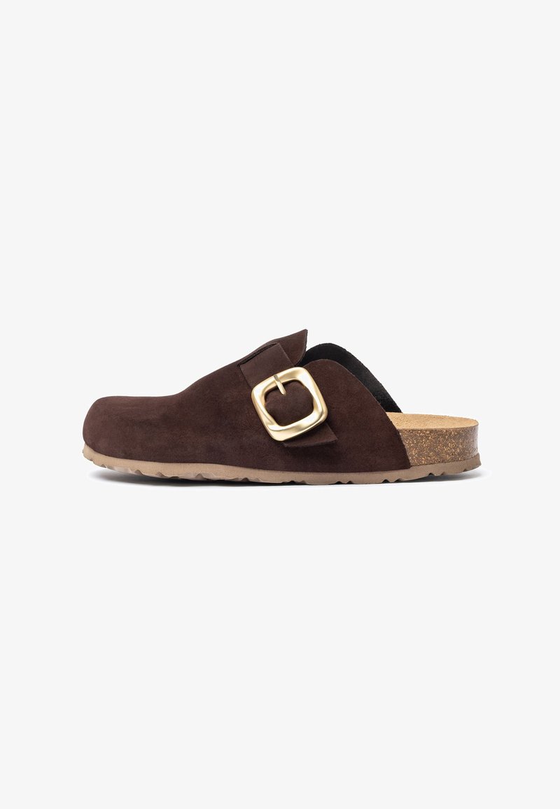 Sabot en daim marron avec une large pointe arrondie et un accent de boucle dorée. Semelle en liège et semelle en caoutchouc texturé pour une bonne adhérence.