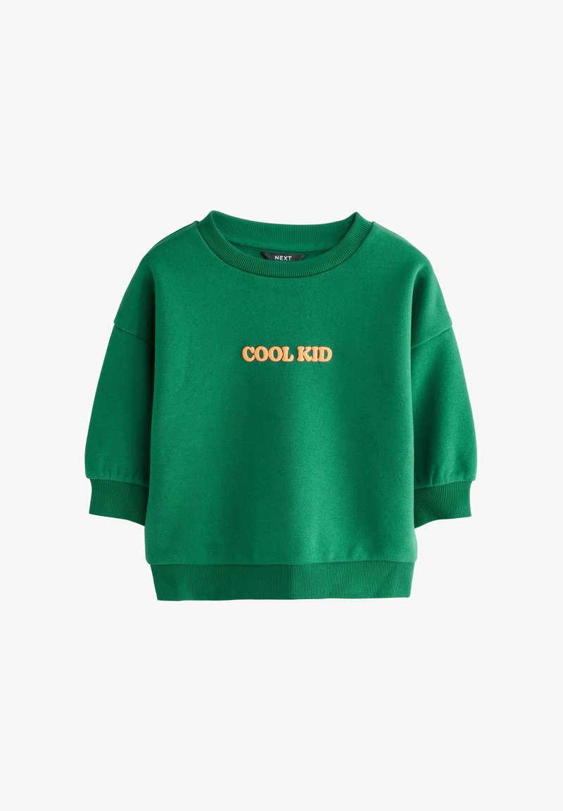 Sudadera verde hecha de una tela suave, con cuello redondo y mangas cortas abullonadas. "COOL KID" está impreso en naranja en la parte delantera.