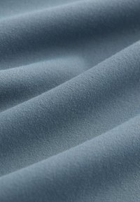 Niebieska tkanina o gładkiej fakturze, z ukośnym wzorem splotu. Powierzchnia delikatnie odbija światło, podkre�ślając jej miękkość i trwałość.