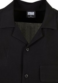 Fekete, rövid ujjú ing, kivágott gallérral, gombos záródással, elülső zsebbel és sima textúrával. Címke: "URBAN CLASSICS, M."