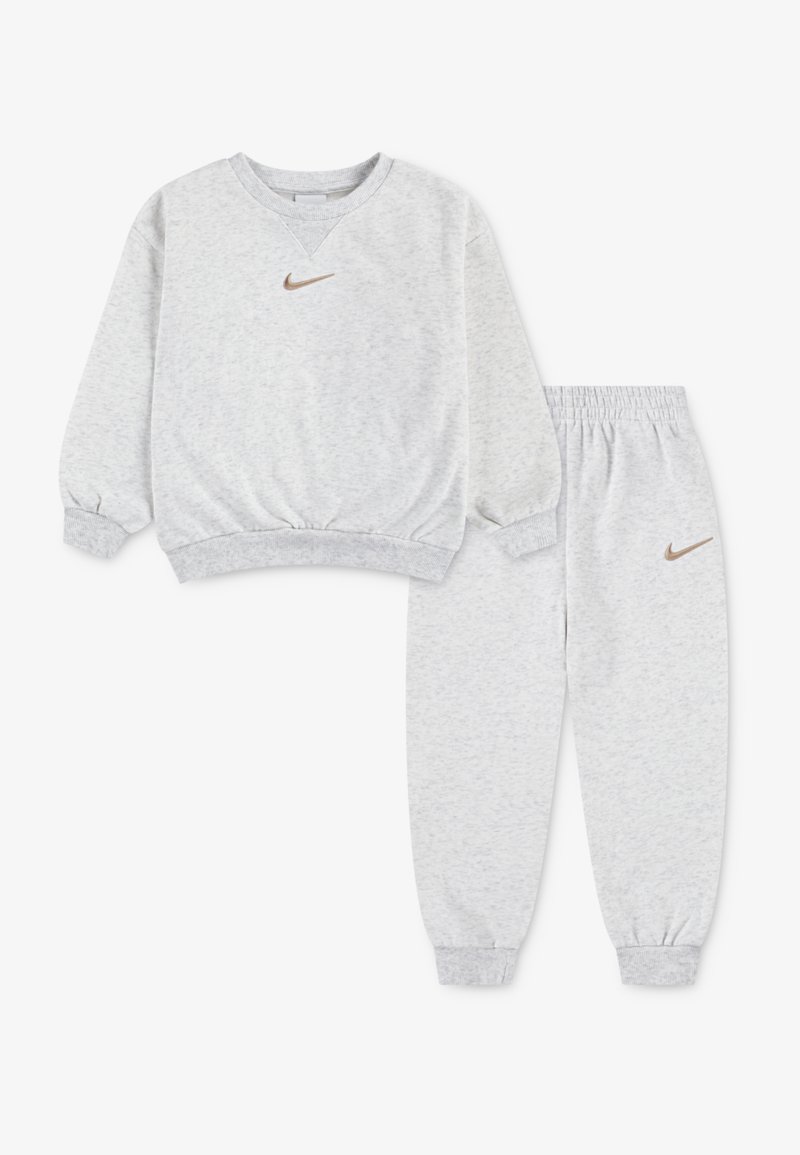 Gråt sweatshirt-sæt med matchende bukser, lavet af blødt stof. Har ribstrikkede manchetter og taljebånd, med en lille brun Nike-logo på begge dele.