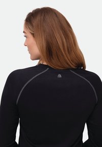 Black long-sleeve shirt with a textured fabric, featuring gray stitching along the shoulders and a small logo on the back neck.