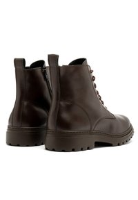 Brązowe skórzane botki za kostkę o gładkiej teksturze, z sznurówkami z przodu i zamkiem błyskawicznym z boku. Grube, wytrzymałe podeszwy oraz subtelne detale w przeszyciach.