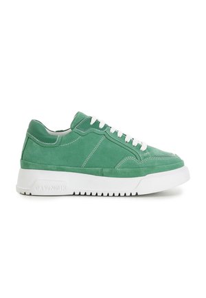 Zapatilla baja de ante verde con cordones blancos y suela gruesa de goma blanca, vista lateral sobre fondo blanco liso.
