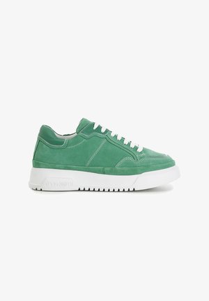 Groene suède lage sneaker met witte veters en dikke witte rubberen zool, zijaanzicht op effen witte achtergrond.