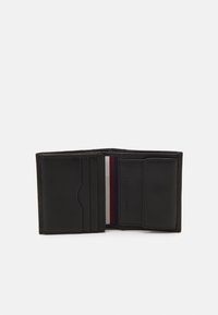 Černá kožená peněženka s několika přihrádkami na karty a texturovaným interiérem s červenými a bílými pruhy. Kompaktní dvouvrstvé provedení.