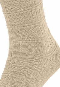 Calzini lavorati a maglia beige con una texture a coste e linee diagonali, che migliorano la presa. Finitura liscia sulle sezioni della punta e del tallone.