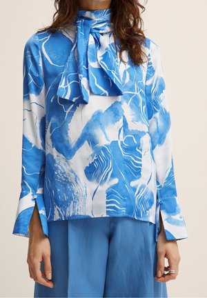 Blå og hvid bluse med abstrakte mønstre, høj hals, bindedetalje, lange ærmer, sideslids, lavet af letvægtsstof.
