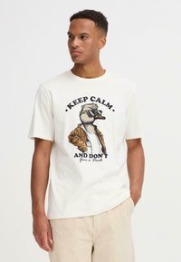 Hvid bomulds t-shirt med et ande-motiv iført solbriller og en brun jakke, med teksten "BEVAR ROEN OG GIV IKKE EN AND" nedenfor.