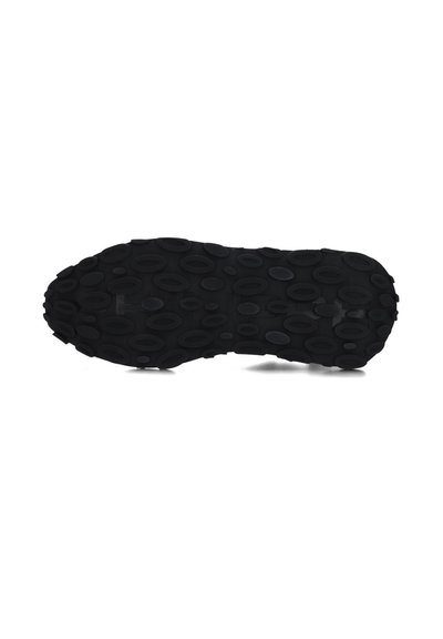 Zwarte rubberen schoenzool met getextureerde cirkelpatronen en verschillende ovale grips voor grip. Gladde randen en een vlak profiel.