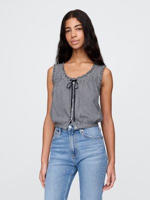 Sorte og hvite gingham uten ermer topp med rynket hals og sløyfedetalj, kombinert med lysebl�å høyhånds jeans.