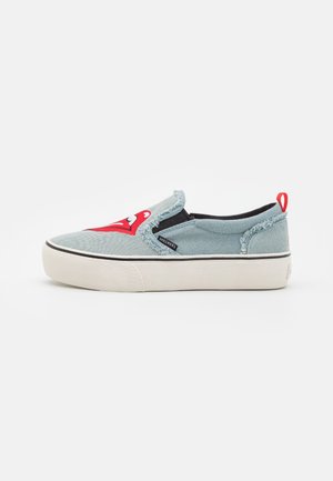 Zapatillas de lona azul de tipo slip-on con un gráfico de logo rojo, acentos laterales elásticos negros, suela de goma blanca y bordes deshilachados en el material superior.