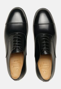 Schwarze Lederschuhe mit einer polierten Oberfläche, die eine abgerundete Zehenpartie, klassisches Schnürdesign und minimale Nähte aufweisen.