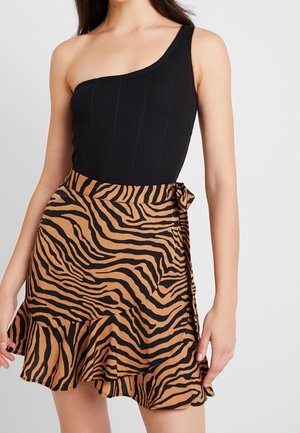 Czarny prążkowany body na jedno ramię w połączeniu z brązowo-czarną spódnicą w paski tygrysie, z falbaną na dole i wiązaniem z boku.