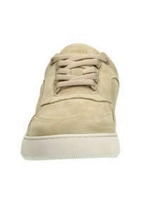 Beige suède sneaker met een textuur bovenkant, ronde neus, bijpassende veters en een rubberen buitenzool met een cirkelvormig grippatroon.