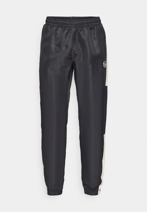 Schwarze Jogginghose aus glattem Stoff, mit einem kontrastierenden beigen Seitenpanel und einem elastischen Bund mit Bündchen an den Knöcheln.