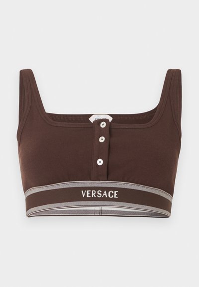 Καφέ κοντό τοπ με τρία λευκά κουμπιά στο κέντρο και λογότυπο Versace στη ελαστική ταινία στο κάτω μέρος.