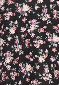 Tissu noir avec un motif floral comprenant des roses roses et pêche clair, des feuilles vertes et de petits bourgeons, créant une apparence texturée et détaillée.