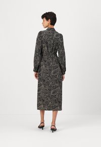 Black paisley-patterned dress with long sleeves and a cinched waist, ending mid-calf. Smooth fabric with a slight sheen. Closed collar design.