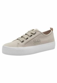 Zapatillas de lona beige con suela de goma blanca, que cuentan con seis ojales, cordones planos y detalle del logotipo grabado en el costado.