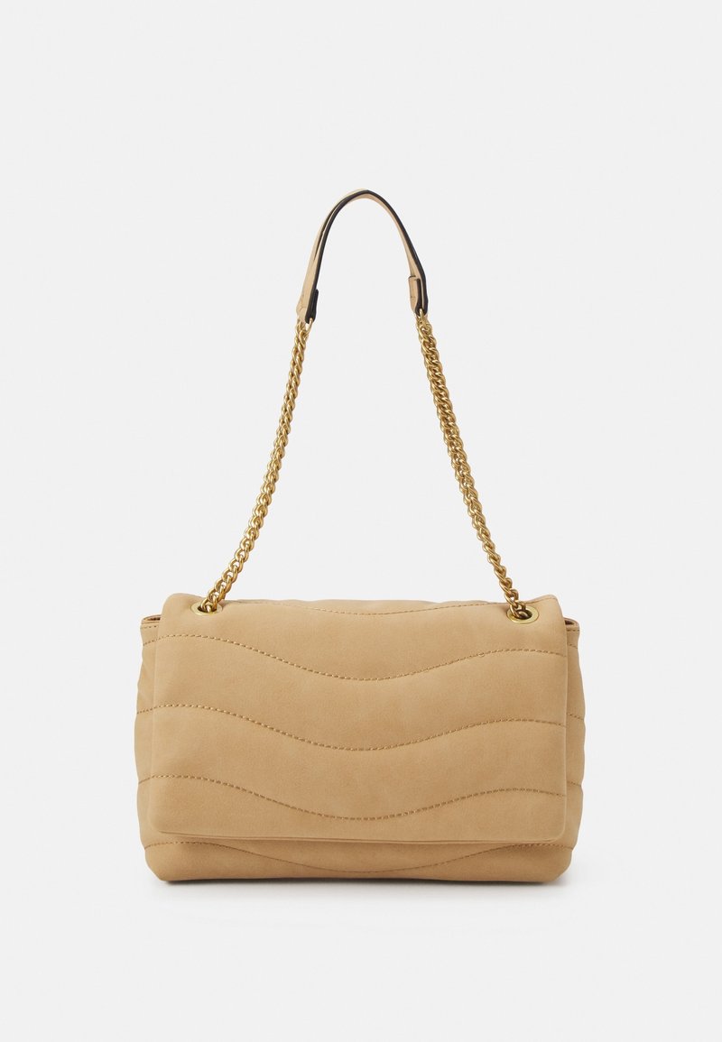 Sac à main matelassé beige avec coutures ondulées et bandoulière chaîne dorée, présenté sur un fond clair uni.