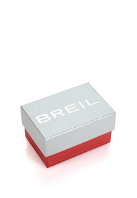 Scatola di imballaggio rettangolare argento e rossa con una superficie texture, caratterizzata dal nome del marchio "BREIL" in lettere bianche in grassetto sul coperchio.