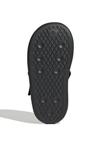 Svart gummisula med ett mönster av texturerade diamanter och sex runda upphöjda grepp. Böjd form med en slät kant. Ingen synlig branding.