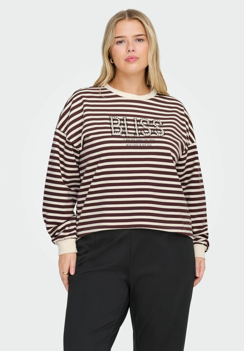 Svītrota sporta jaka brūnā un krēmkrāsas krāsā ar nokritušām plecu šuvēm, apaļu kakla izmēru un "BLISS" teksta dizainu, kas ietver dekoratīvas detaļas.