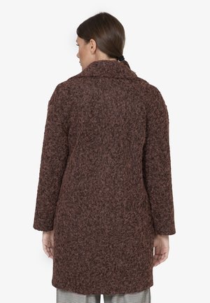 Bruine textuur jas met een relaxte pasvorm, met een brede kraag, lange mouwen en tot halverwege de benen, gedragen over geruite broek.