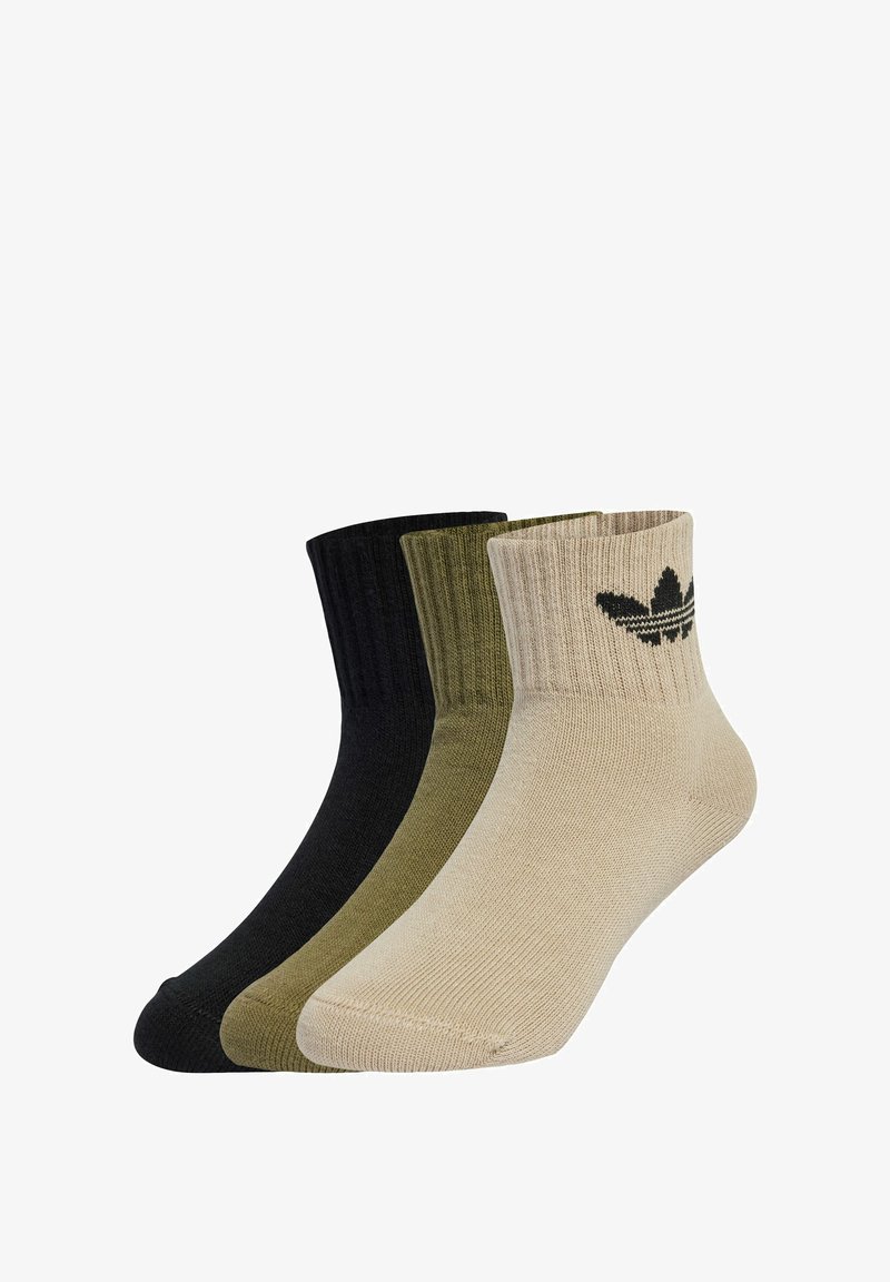 Tre paia di calzini corti nei colori nero, oliva e beige. Texture a costine con un logo sul calzino beige, che evidenzia la varietà di colori e lo stile.