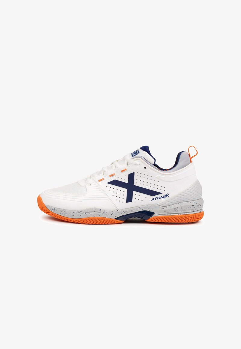Chaussure de sport blanche avec accents bleu marine et semelle orange. Présente des panneaux latéraux perforés, un talon texturé et un design amorti pour la performance.