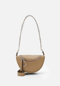 Borsa a mano in pelle color tan a forma di mezzaluna, con tracolla in catena argentata, chiusura con zip e un accento a forma di anello per chiavi rotondo. Texture liscia.