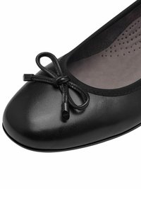 Ballet flat nera con punta tonda, finitura in pelle liscia, dettaglio a fiocco regolabile davanti e interno imbottito con perforazioni.