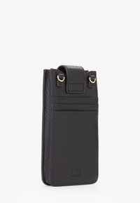 Custodia per telefono in pelle nera con finitura strutturata, dotata di patta superiore, accessori dorati e tasca frontale per riporre le carte.