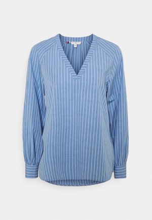 Blauwe blouse met lange mouwen en witte verticale strepen, V-hals en manchetten met knopen, getoond op een effen achtergrond.