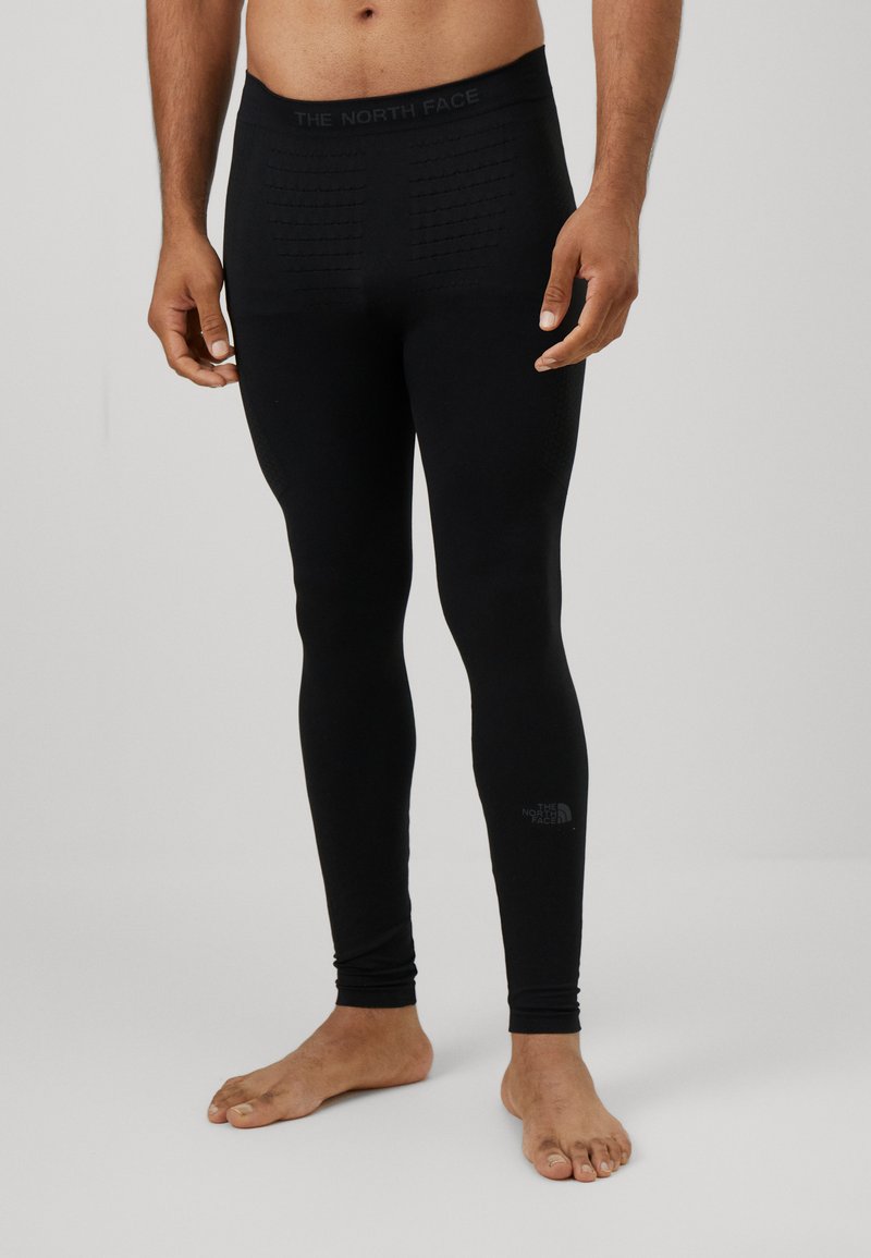 Leggings thermiques noirs avec une taille et un corps texturés, design ajusté, arborant le logo de The North Face près de la cheville.