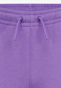 Pantaloni sportivi viola con vita elastica e cordini, texture morbida e finitura liscia. Design semplice senza motivi visibili.