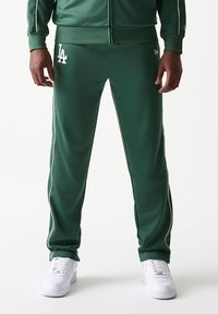 Πράσινο αθλητικό παντελόνι από λείο πολυεστέρα με λευκή ρίγα στο πλάι, με κεντημένο λογότυπο "LA" στο αριστερό μηρό.