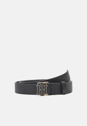 Zwart gestructureerde leren riem met een gouden gesp met het verstrengelde "TH" logo, opgerold en weergegeven op een effen lichte achtergrond.