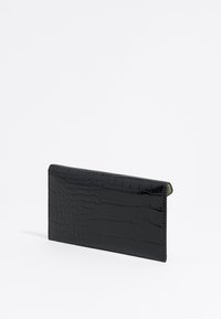 Cartera negra con estampado de cocodrilo, de forma rectangular delgada, acabado brillante y textura suave. Sin herrajes ni acentos visibles.