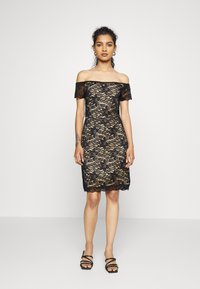 Vestido preto de renda com um design off-the-shoulder, corte até ao joelho e intrincado padrão floral. Renda texturizada com silhueta ajustada.