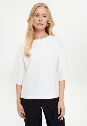 White, soft, textured sweater with a round neckline and elbow-length sleeves, paired with black trousers. Simple, minimalistic design.