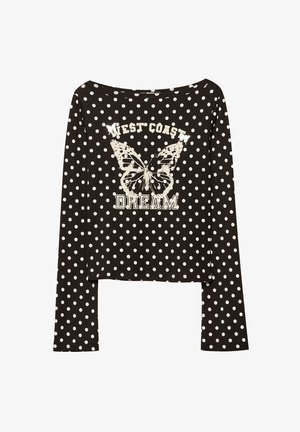 Zwarte langemouwen shirt met witte stippen, met een vlinderafbeelding en de tekst "WEST COAST DREAM" in een verouderde stijl.
