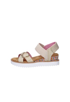 Beige sandaal met open teen, gouden hartgesp, roze voering, elastische enkelriem en meerkleurige geweven details op de plateauzool.