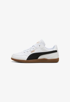 Low-top white Puma sneaker with black side stripe, gum sole, white laces, and gold Puma logo on side and tongue.