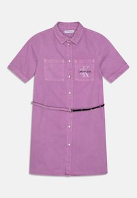 Sukienka na krótki rękaw, zapinana na guziki, w jasnofioletowym dżinsie. Posiada dwie kieszenie na piersi, logo Calvin Klein oraz czarny pasek w talii.