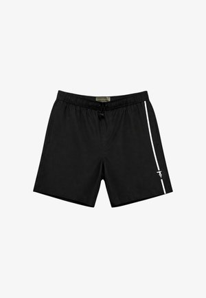 Pantaloncini neri con vita elastica, tasche laterali e una striscia verticale bianca con un piccolo logo sulla parte inferiore della gamba destra.